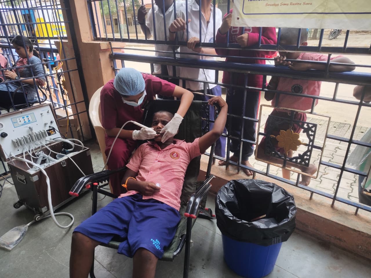 Dentist performing oral prophylaxis on a student on Day 1